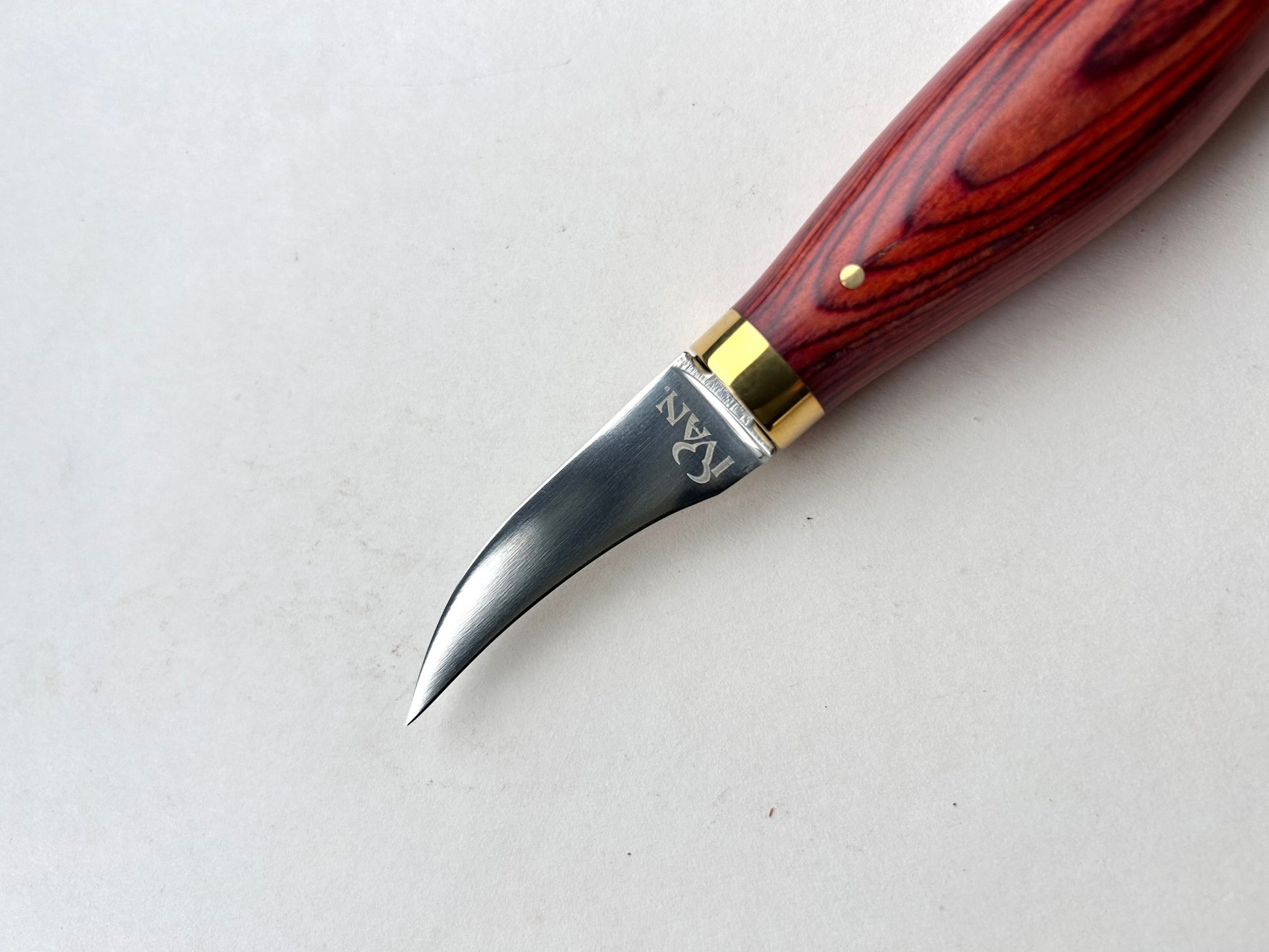 Wooden-handled clicker knife for leather with metal blade on a white background