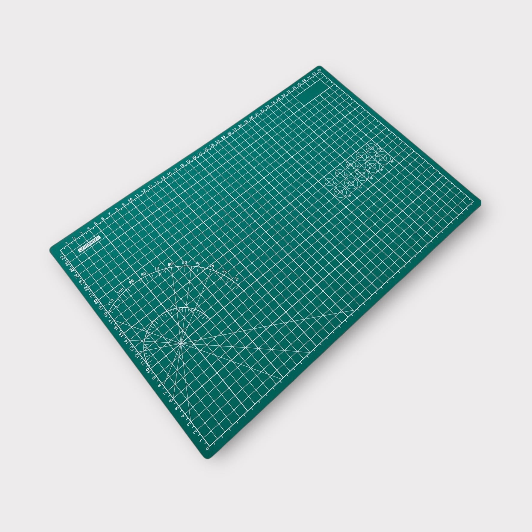 Green cutting mat with grid lines on a white background