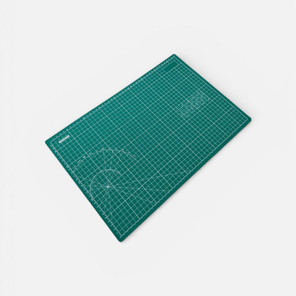 Green cutting mat with grid lines on a white background
