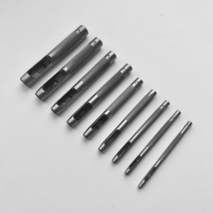 Set of metal leather drive punch tools on a grey background