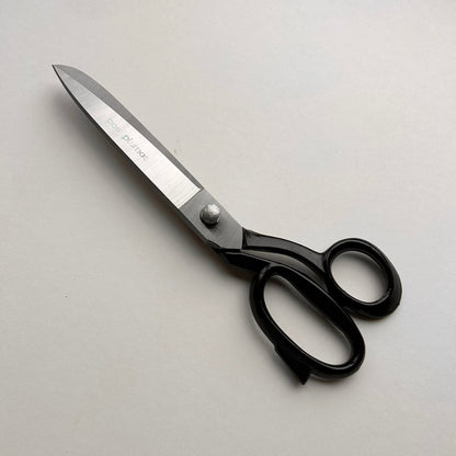 Pair of leather scissors with black handles on a white background