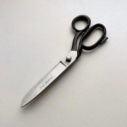 Pair of leather scissors with black handles on a white background