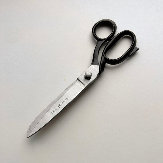 Pair of leather scissors with black handles on a white background