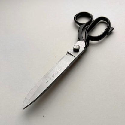 Pair of leather scissors with black handles on a white background