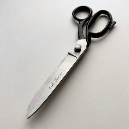 Pair of leather scissors with black handles on a white background