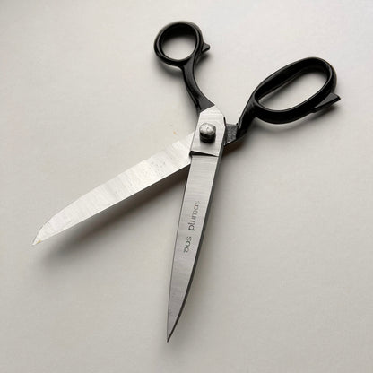 Pair of leather scissors with black handles on a white background