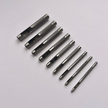 Set of metal leather drive punch tools on a grey background