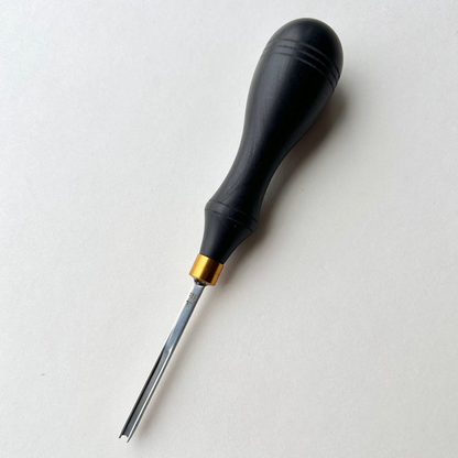 Ebony-handled leather edge beveller on a white background