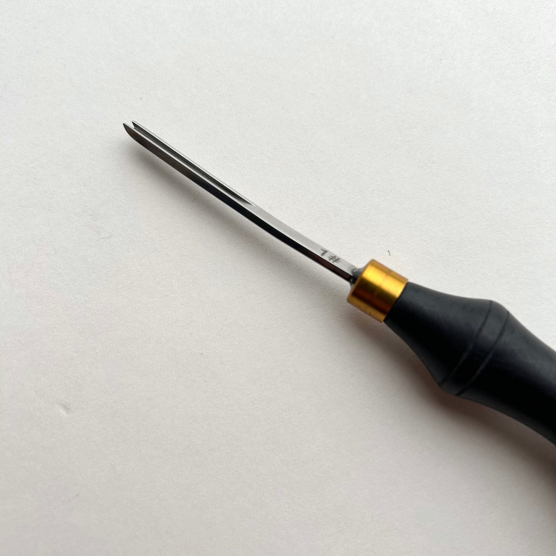 Ebony-handled leather edge beveller on a white background