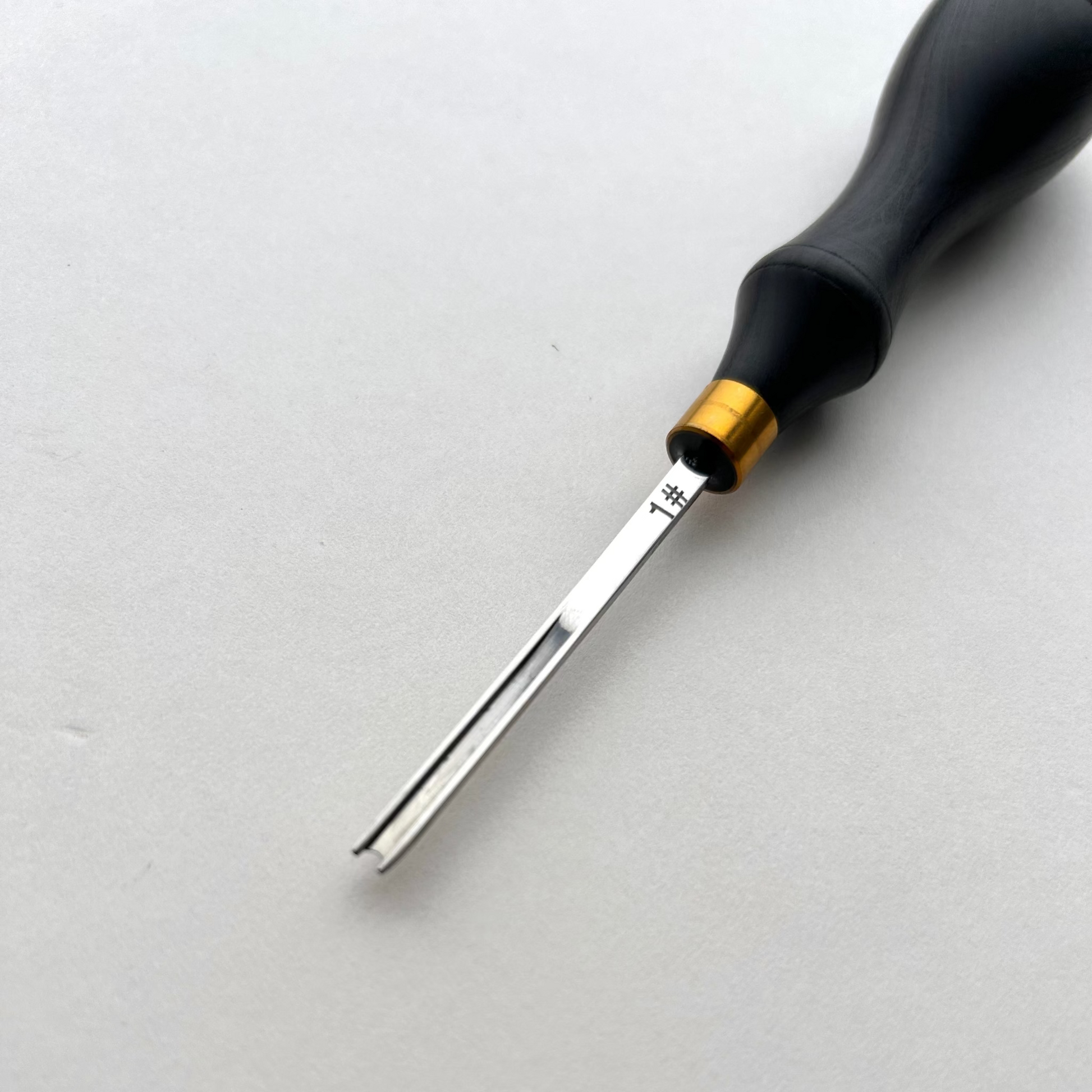Ebony-handled leather edge beveller on a white background