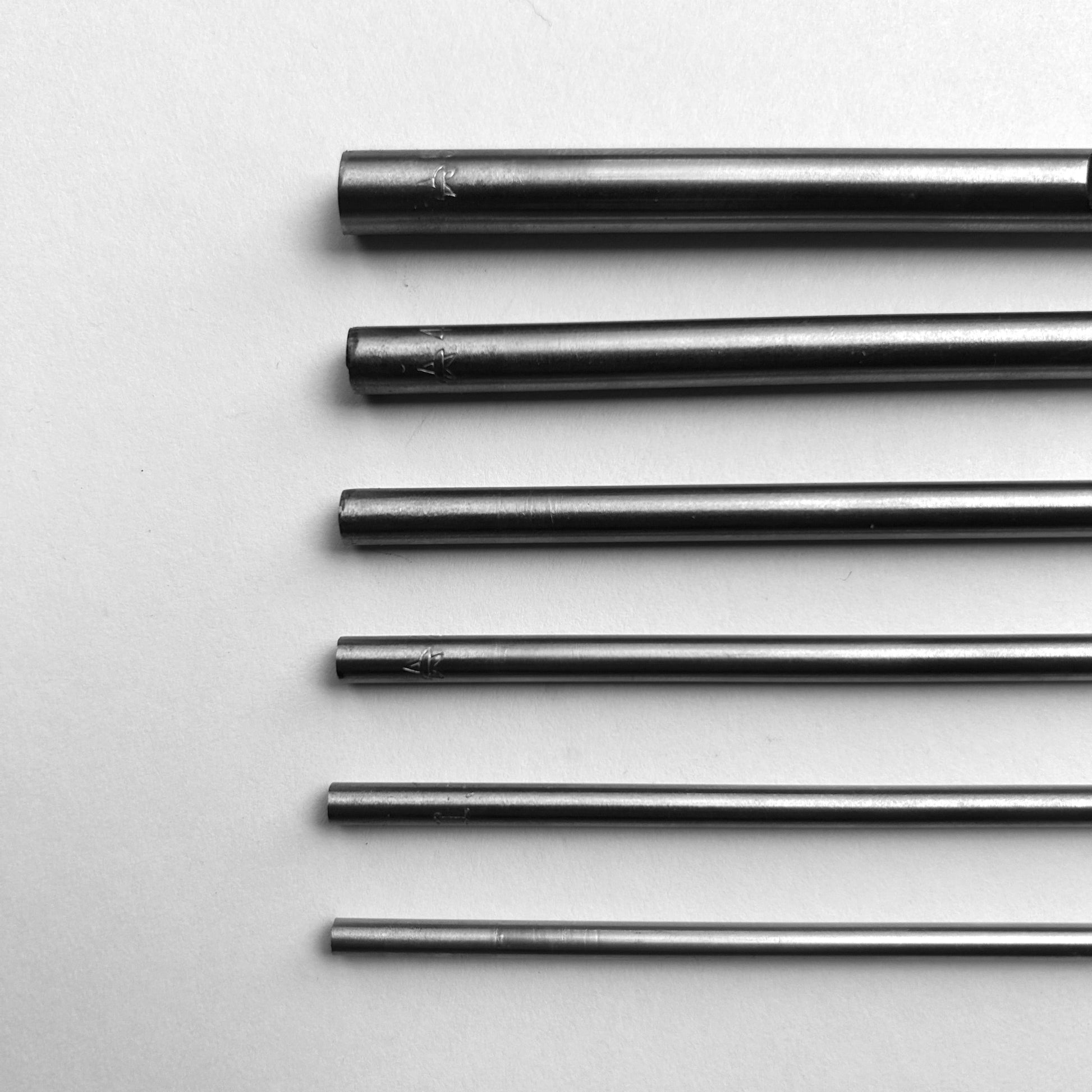 Set of six leather hole punch tools on a white background