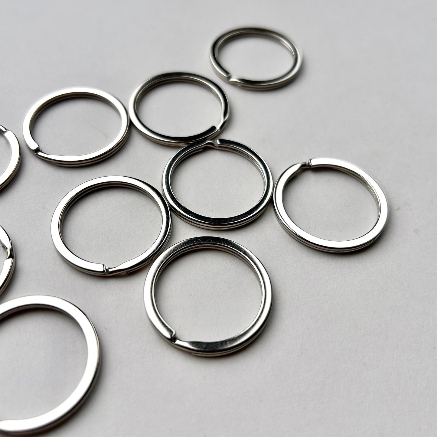 Silver keychains scattered on a gray surface