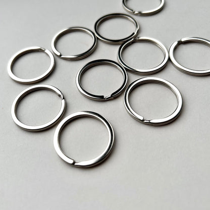 Multiple silver keyrings on a grey background