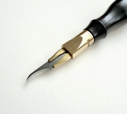 A leather clicker knife tool with a black wooden handle, brass collar, and sharp silver metal blade, photographed on a plain light background.