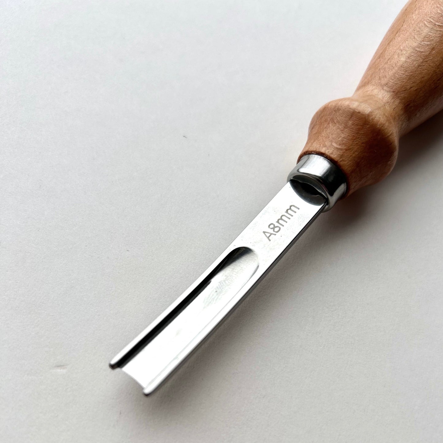 Wooden-handled french leather edge skiver tool on a white background