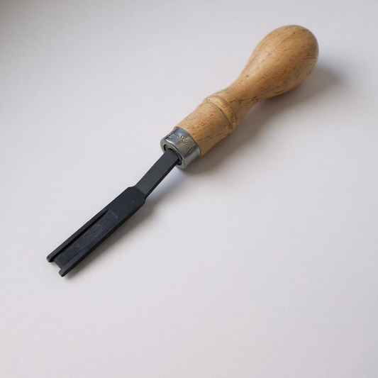 Wooden-handled leather edge skiver tool on a light grey background