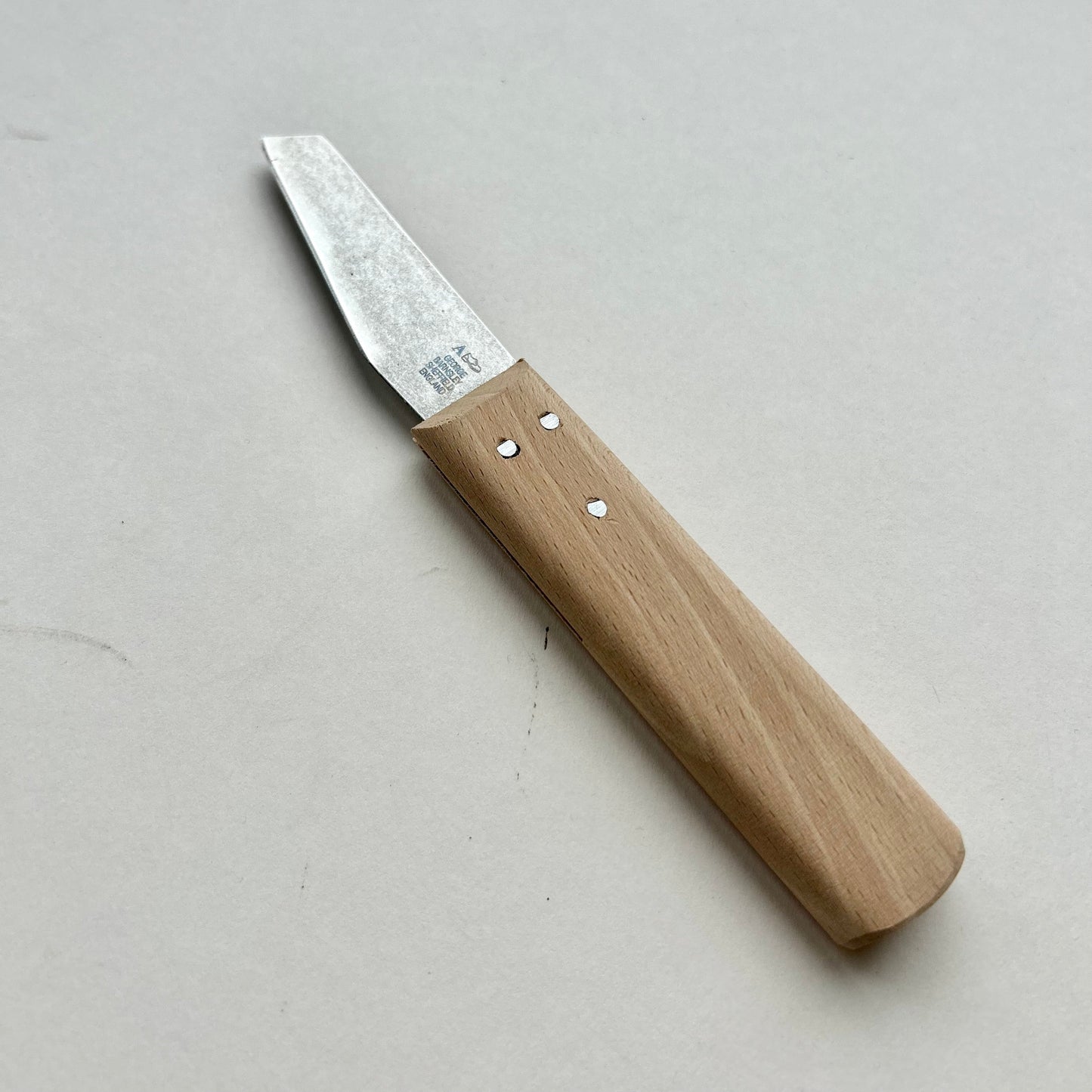 Small knife with wooden handle on a light gray background