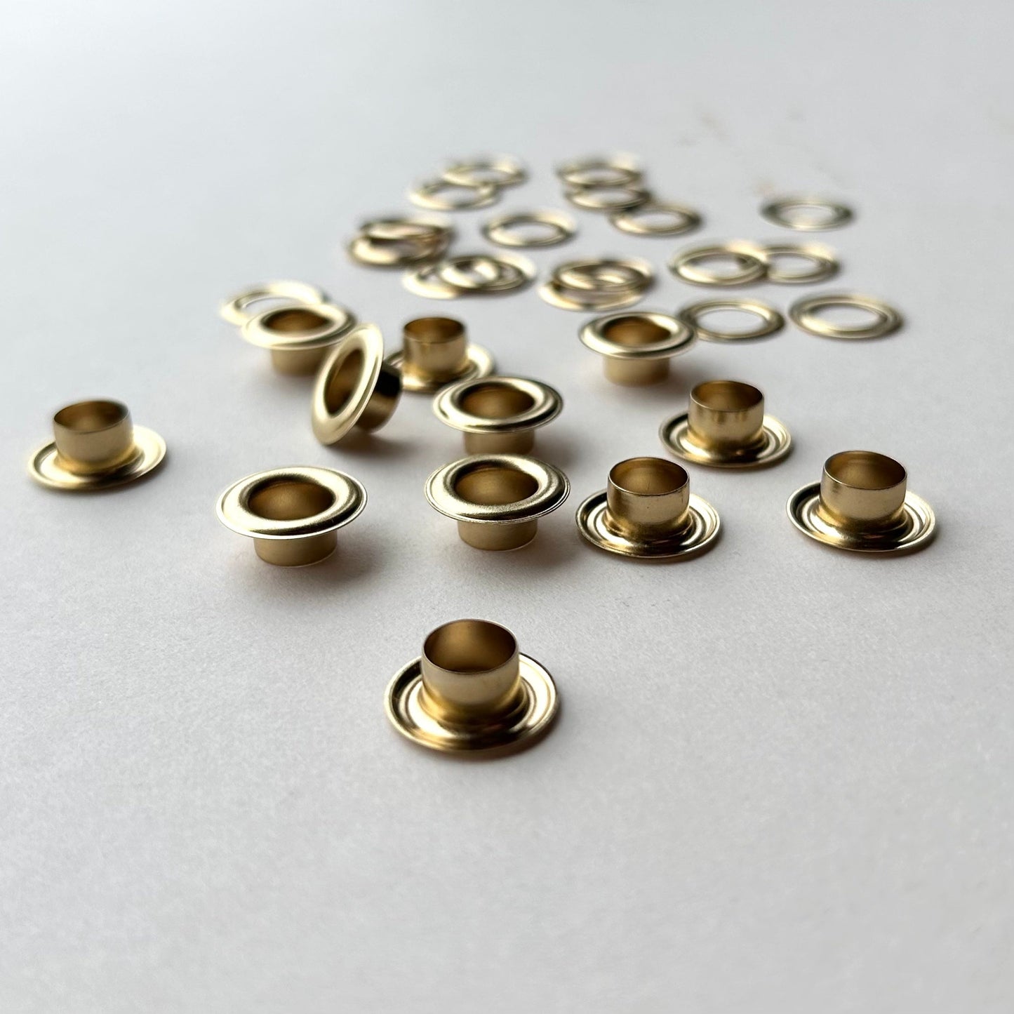 Gold metal eyelets on a light gray background