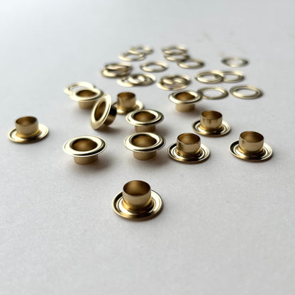 Gold metal eyelets on a light gray background