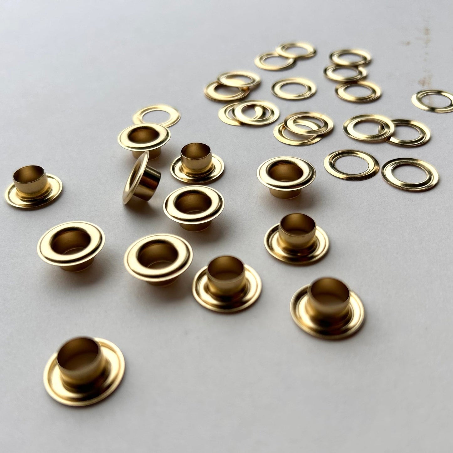 Gold metal eyelets and grommets on a gray background