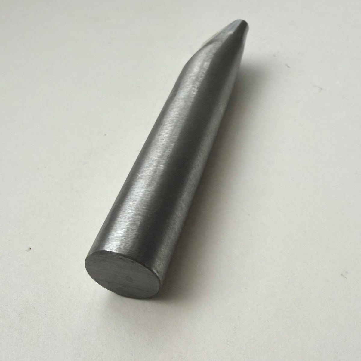 A metallic oblong punch for leather on a white background