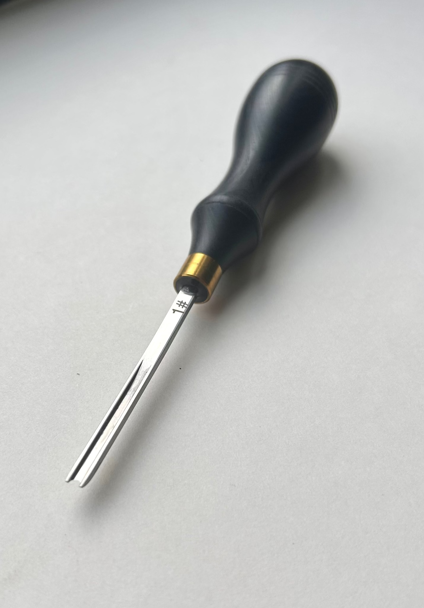 Ebony-handled leather edge beveller on a white background