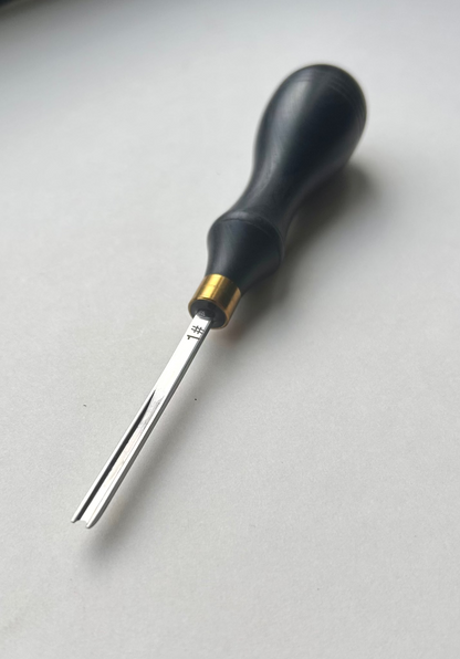 Ebony-handled leather edge beveller on a white background