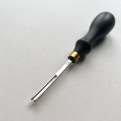 Ebony-handled leather edge beveller on a white background