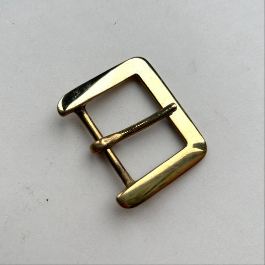 Gold metal buckle on a light gray background