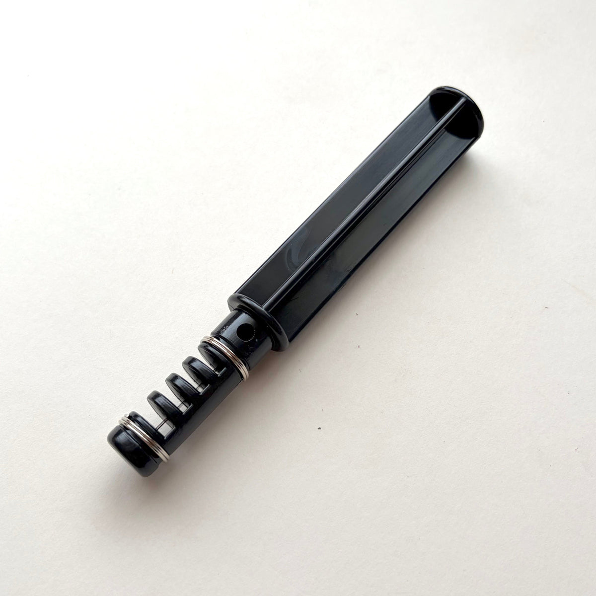 Black plastic leather lace maker tool on a grey background.
