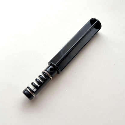 Black plastic leather lace maker tool on a grey background.