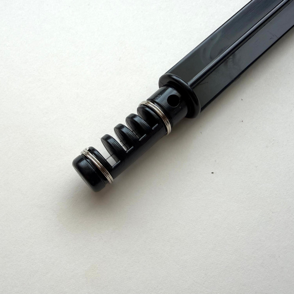Black plastic leather lace maker tool on a grey background.