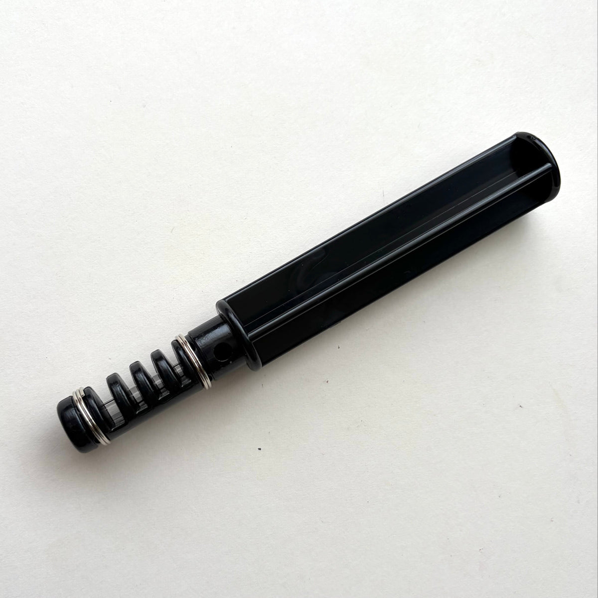 Black plastic leather lace maker tool on a grey background.