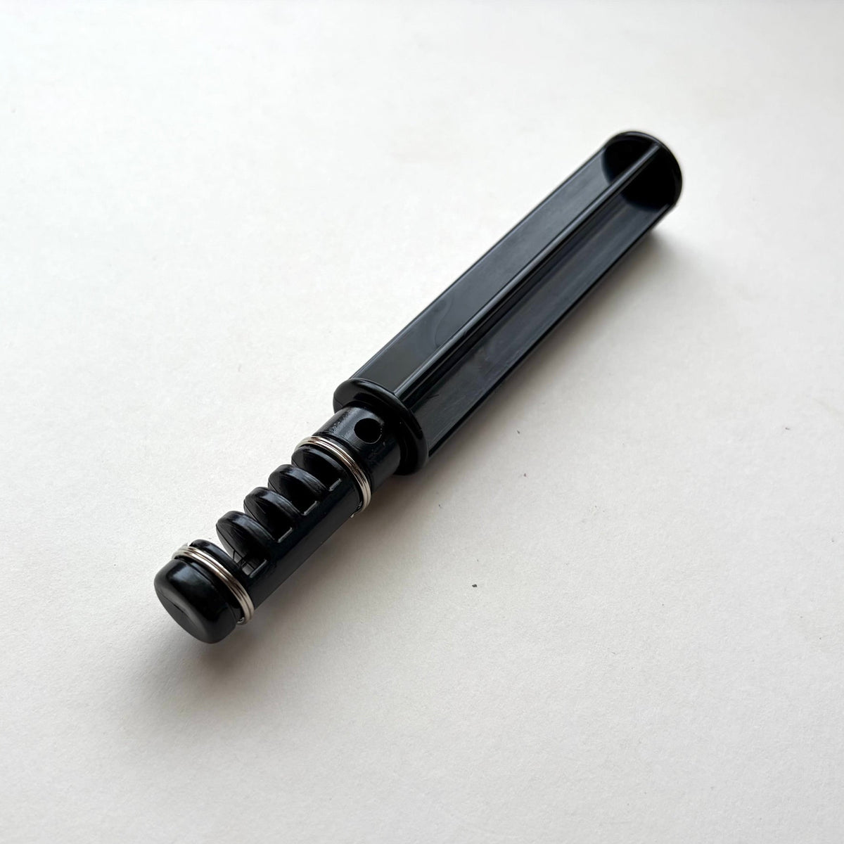 Black plastic leather lace maker tool on a grey background.