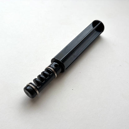 Black plastic leather lace maker tool on a grey background.