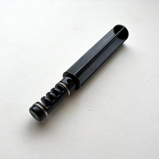 Black plastic leather lace maker tool on a grey background.