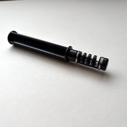 Black plastic leather lace maker tool on a grey background.