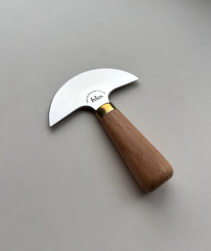 Round head leather knife with wooden handle on a grey background