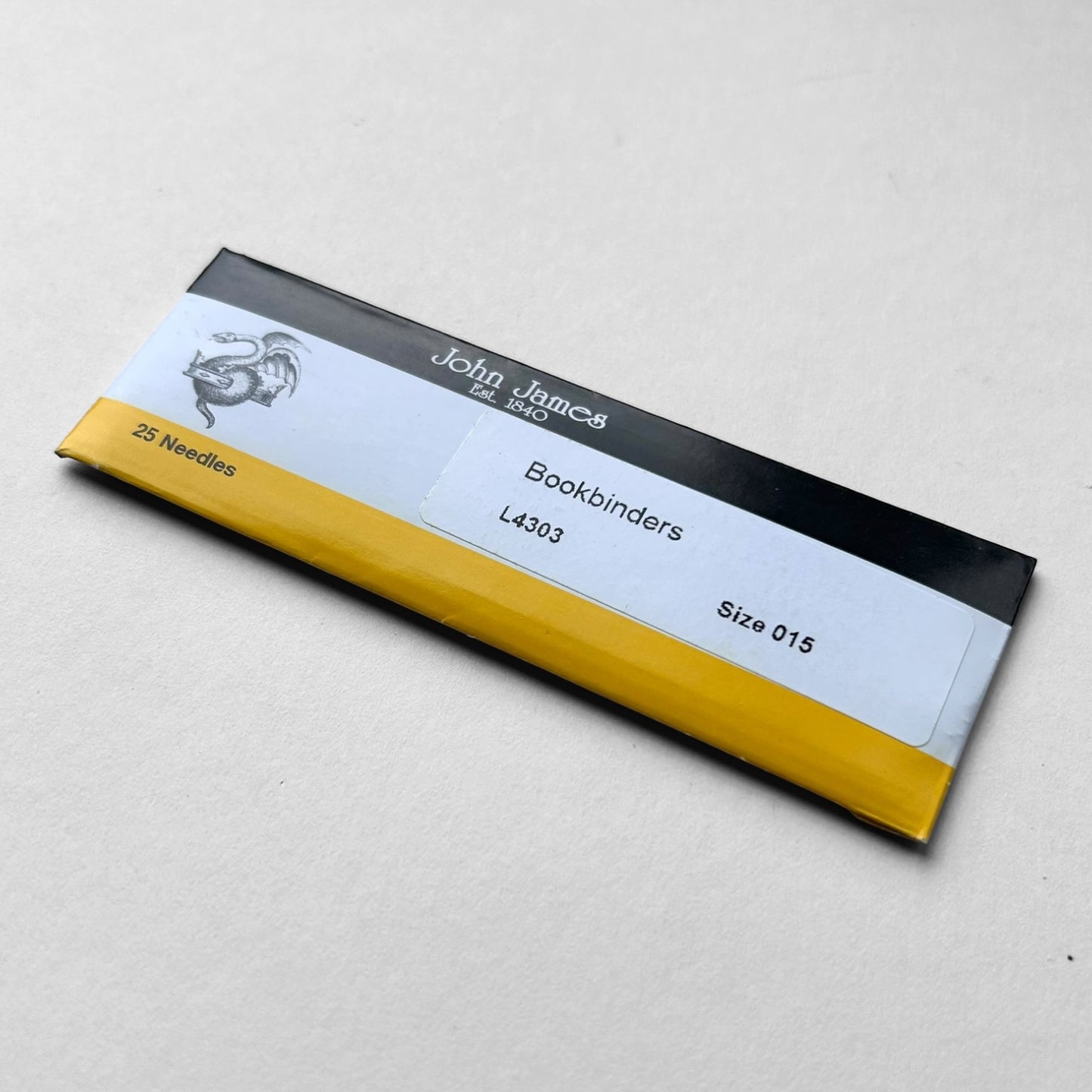 Pack of John James bookbinders needles on a light gray background