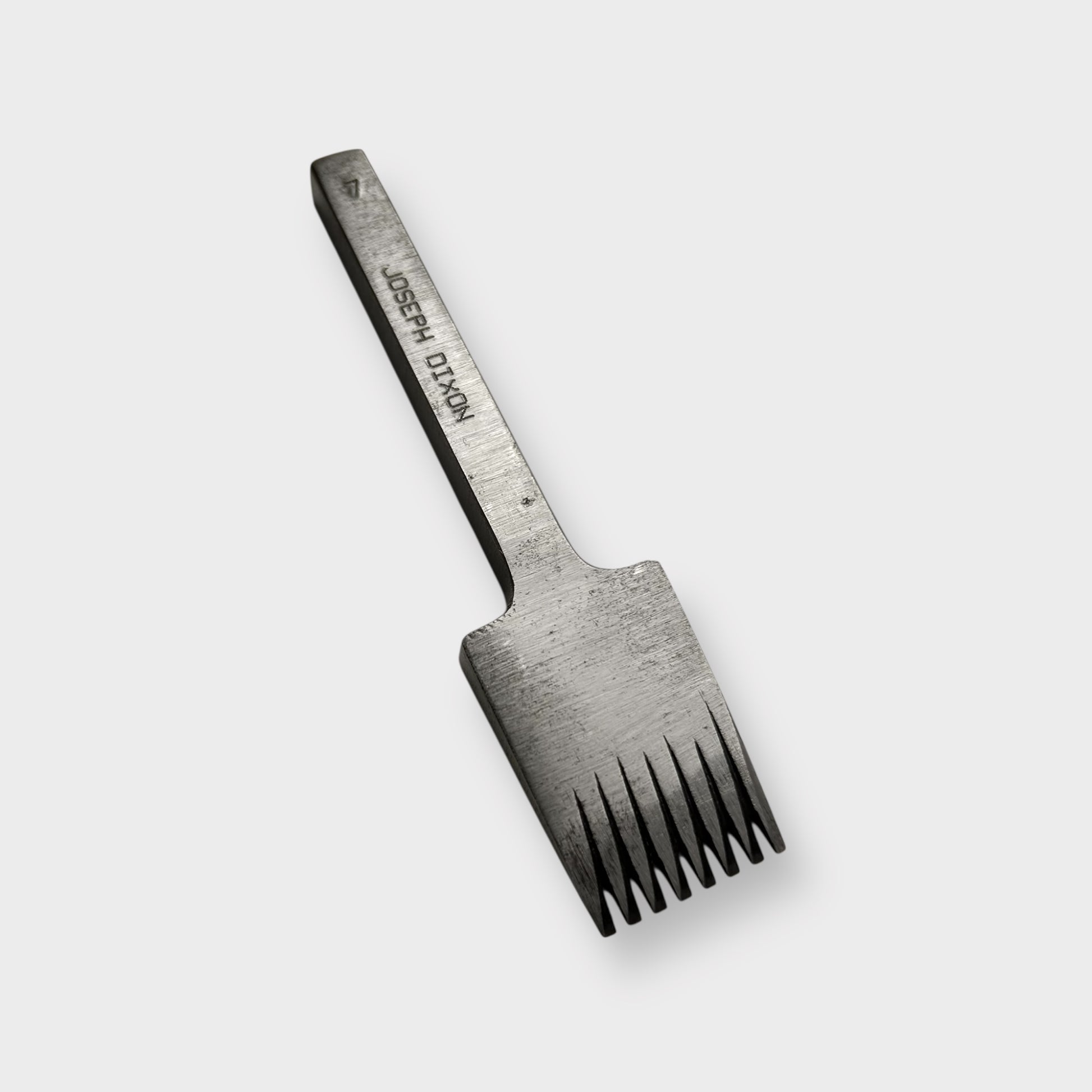 Metallic pricking iron leather tool with 'JOSEPH DIXON' engraving on a light gray background.