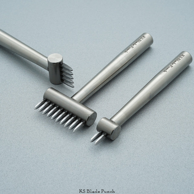 Set of metal blade punches on a light grey background