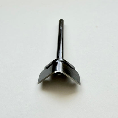 A black metal corner punch for leather with a long straight black handle, photographed on a plain light grey background.