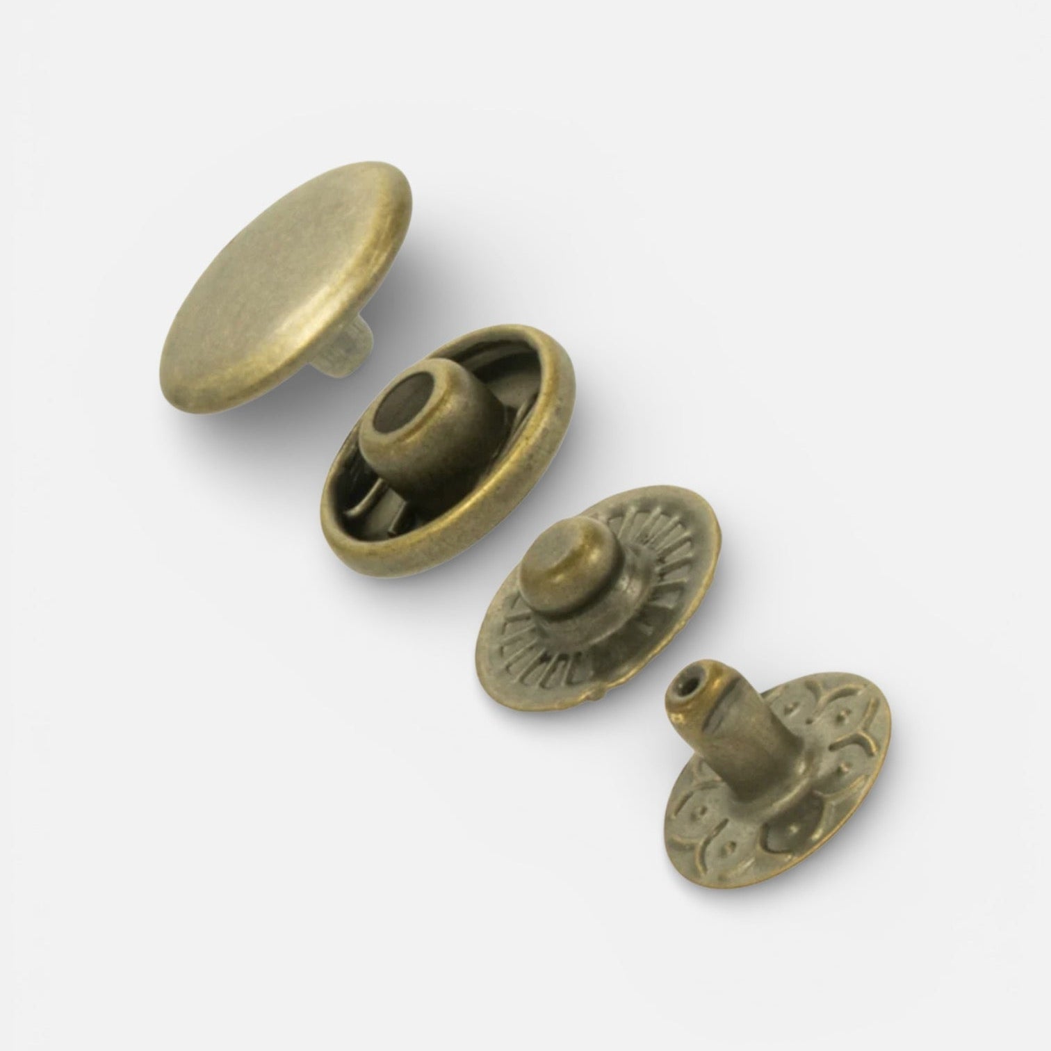 Large antique brass glove snaps on a white background