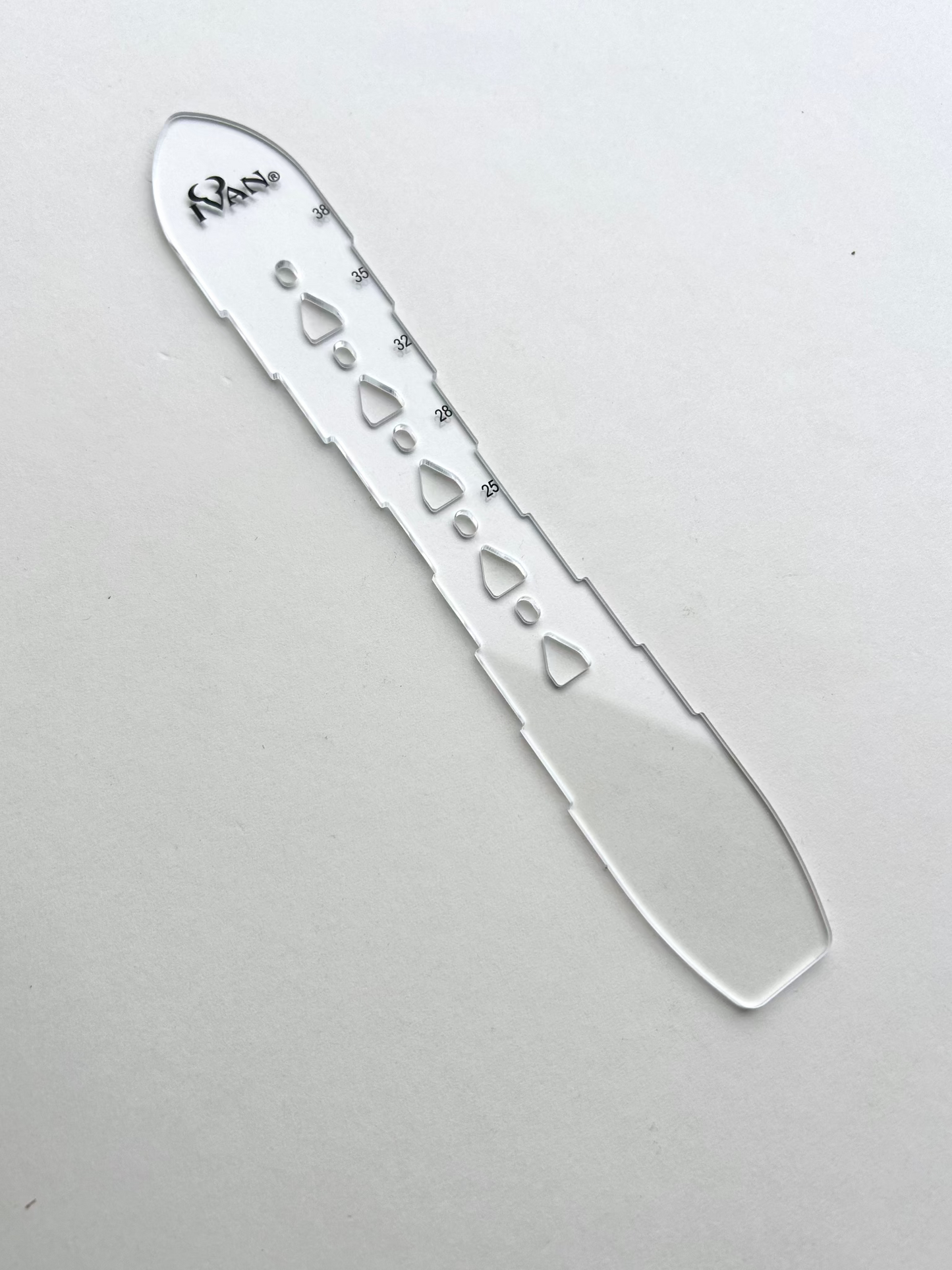 Leather belt hole template on a grey background