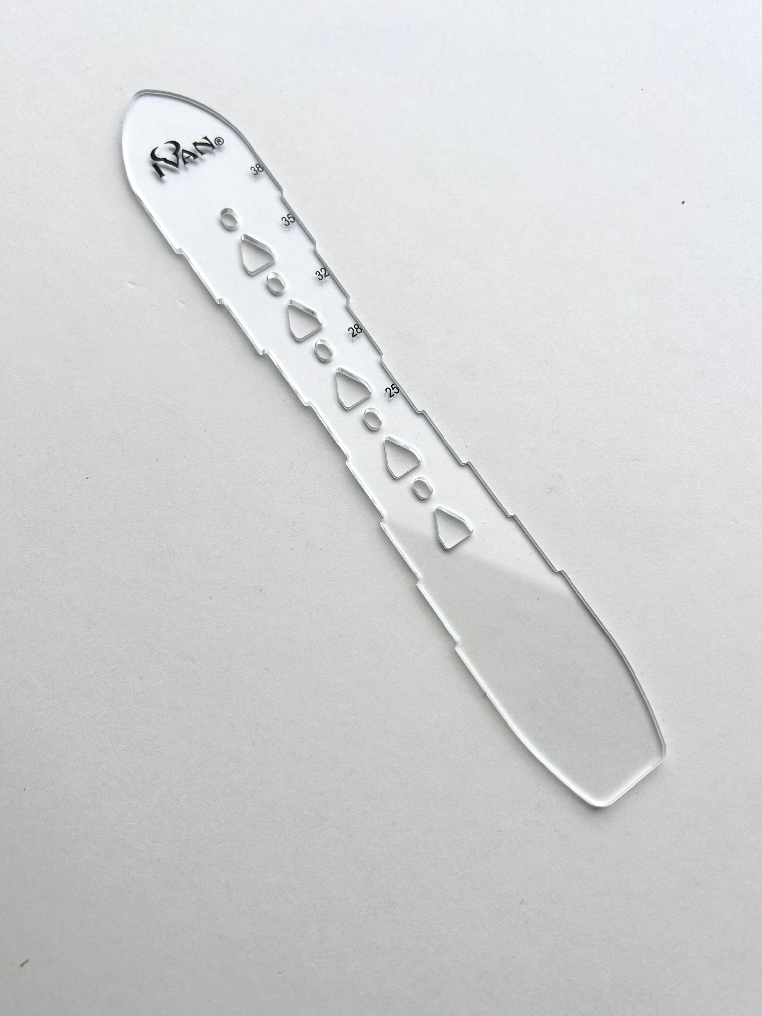 Leather belt hole template on a grey background