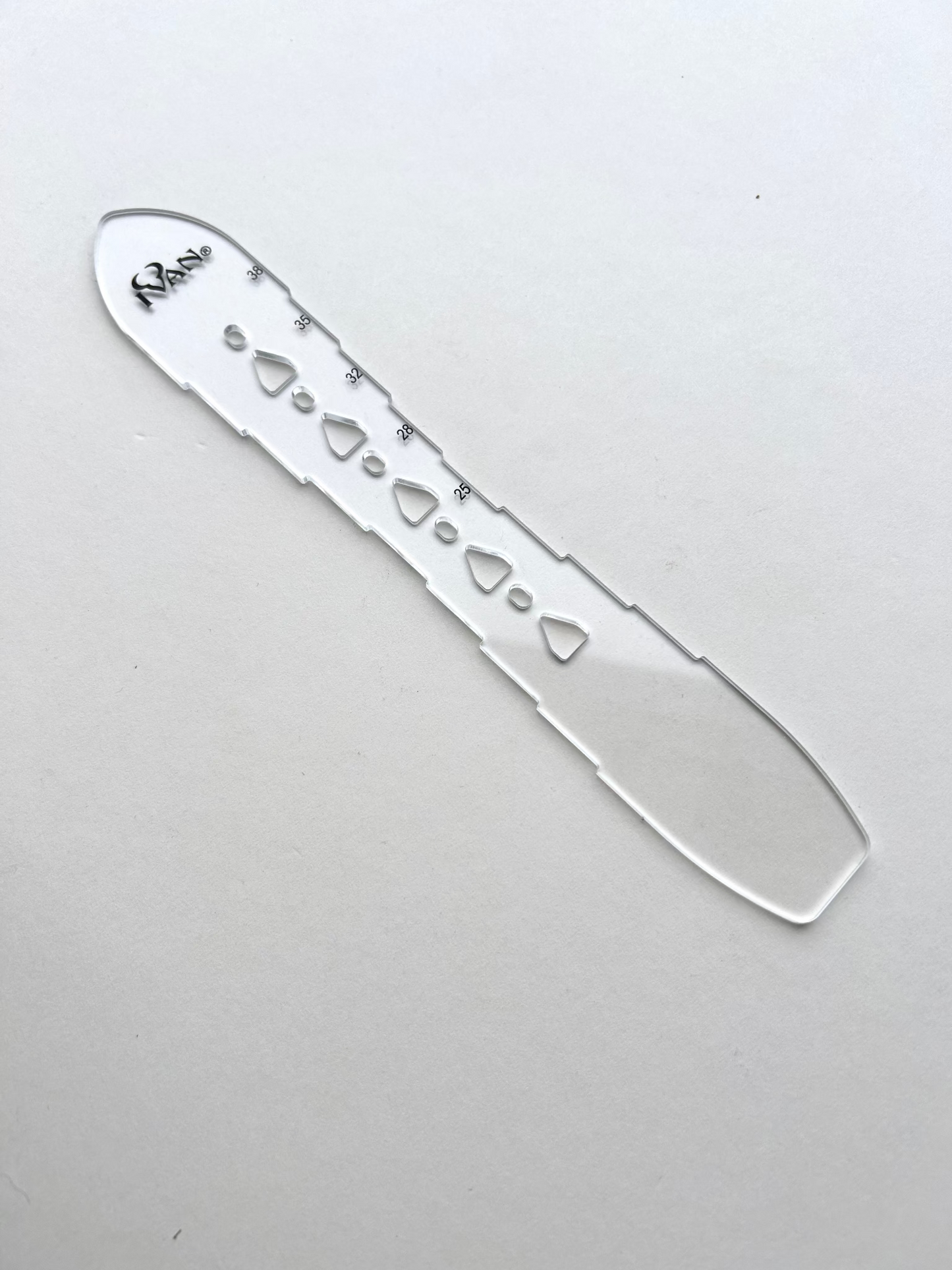 Leather belt hole template on a grey background