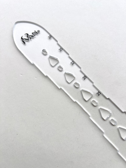 Leather belt hole template on a grey background