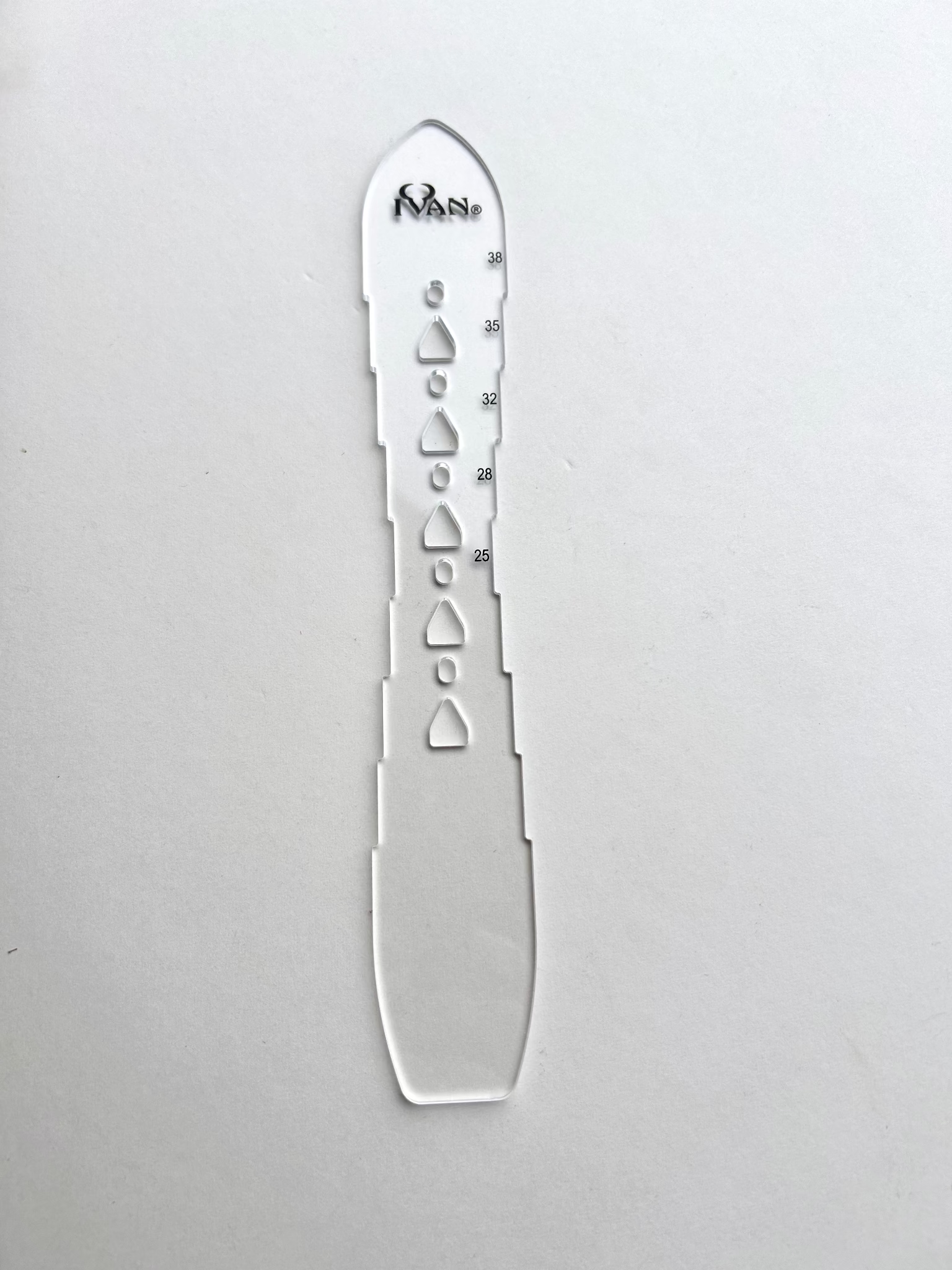 Leather belt hole template on a grey background