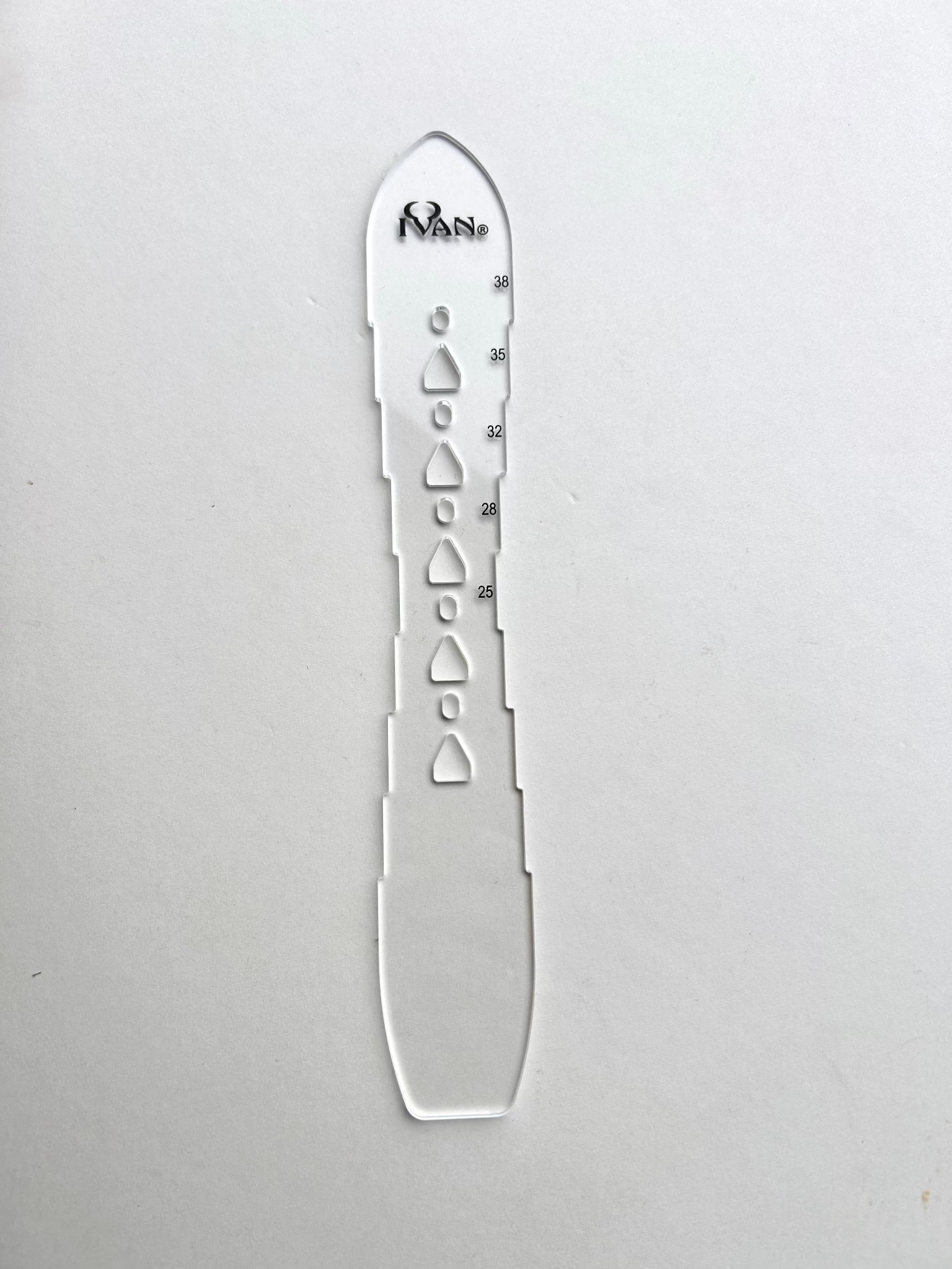 Leather belt hole template on a grey background