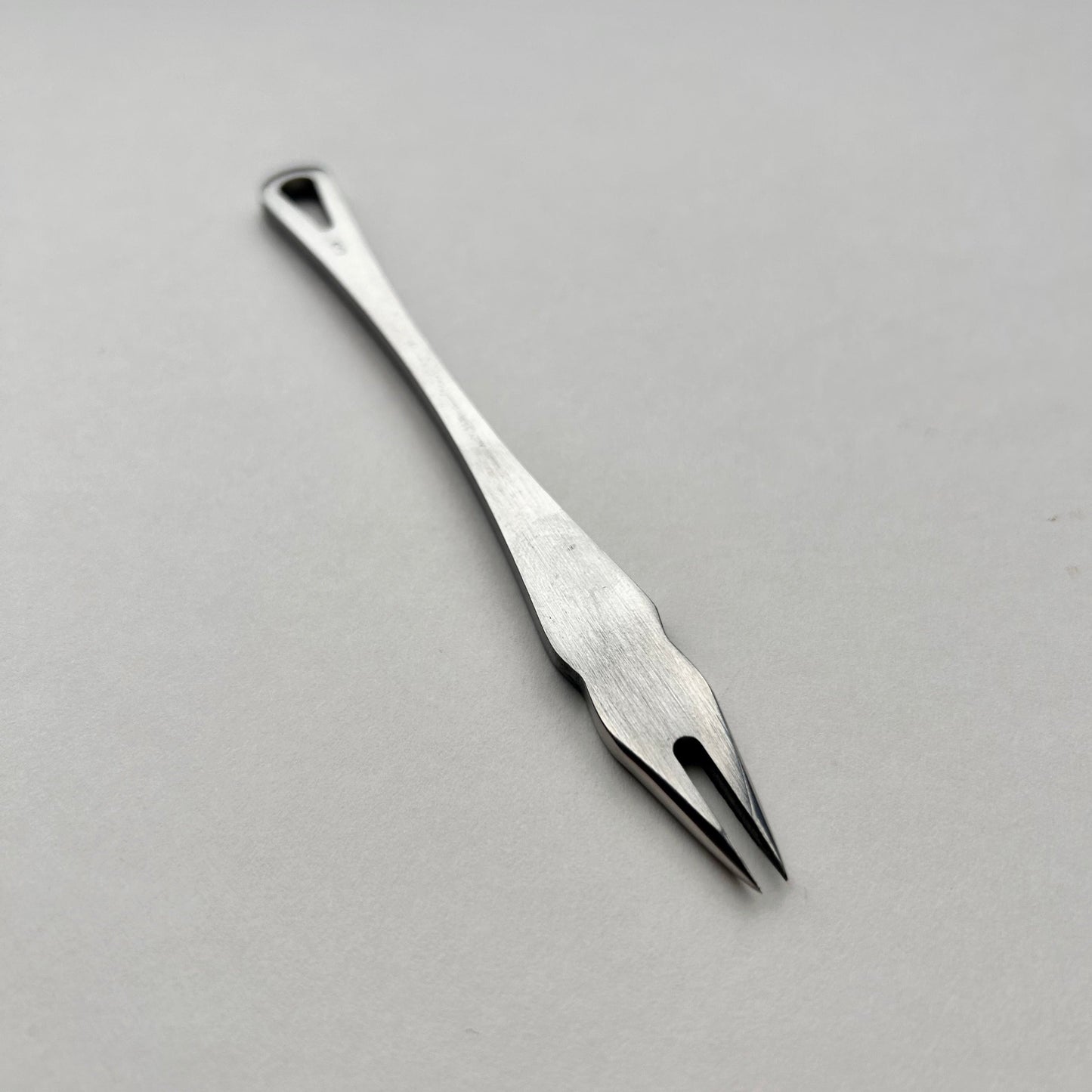 Metal distance gauge tool on a piece of leather